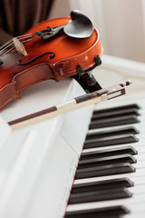 Musical instruments: the violin lies on an electronic piano. Music concept