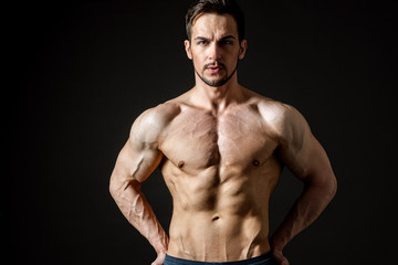 Fototapeta na wymiar Portrait of an attractive muscular man on a dark background