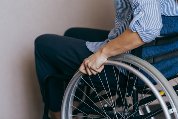 Unrecognizable disabled woman in wheelchair at home. Recovery and healthcare concepts.
