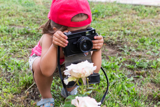 little girl shooting blog on retro photo camera сlose up.