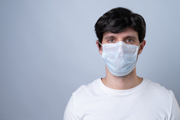 Man in a medical mask, isolated on a gray background