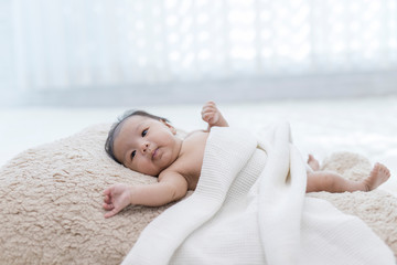Asia baby sleep on a white and brown background.