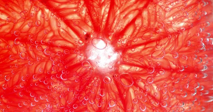 Slice fresh ripe grapefruit under water with air bubbles.