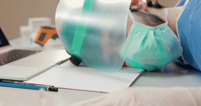 Medico o infermiere provato che dorme sulla scrivania o tavolo dell'ospedale dopo un turno in terapia intensiva a curare i malati di coronavirus.