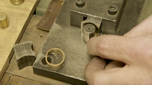 Goldsmith uses a Bending machine to create a gold ring close up.