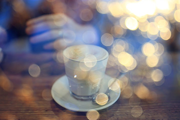 cup of cappuccino in a cafe in hands, coffee in a restaurant interior