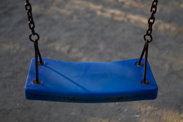 blue playground swing with rusty chains