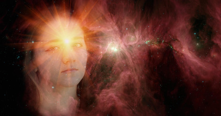 Fototapeta na wymiar The face of a young clairvoyant girl against the background of galaxies with a shining star in her forehead.The concept of clairvoyance,paranormal abilities.Elements of this image are provided by NASA