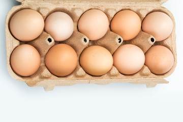  chicken eggs in an open cardboard box with eggs isolated on white. Fresh chicken eggs background.