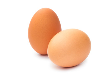 Two fresh brown chicken eggs on a white background