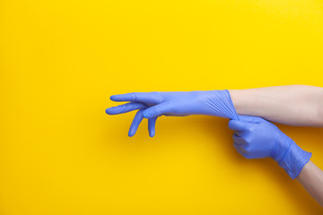 Doctor putting on hand nitrile professional medical purple gloves