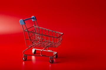 Empty Groceries trolley on red background