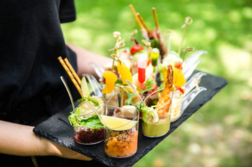 Canape, appetizers, on the table, buffet menu, European cuisine, shrimp, mini burger on a wooden...