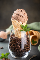 Delicious coffee or chocolate ice cream in waffle cone for dessert. Summer healthy food concept, lactose free.