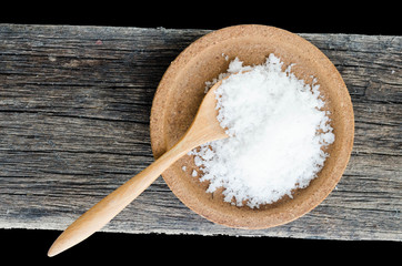 Fototapeta na wymiar salt on a black background,salt on wooden spoon isolated on white background,A pile of coarse salt on a black background