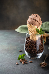 Delicious coffee or chocolate ice cream in waffle cone for dessert. Summer healthy food concept, lactose free. Copy space.