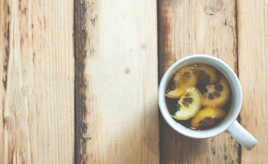 A cup of tea with lemon. On a wooden table.