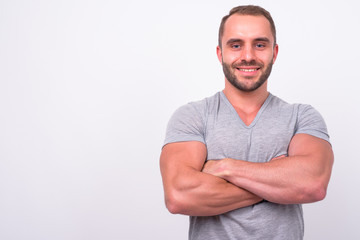 Fototapeta premium Portrait of happy muscular bearded man smiling with arms crossed