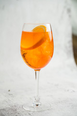 Aperol Spritz cocktail in a glass with ice and orange on a light background