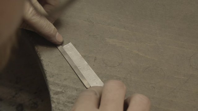 goldsmith measuring a piece of gold 