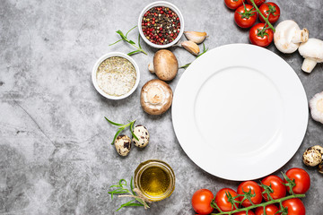 Empty white plate and various fresh food on black stone background with copy space for your design. Template food blog social media.