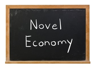 Fototapeta premium Novel Economy written in white chalk on a black chalkboard isolated on white