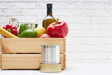 Food stocks in a wooden box. Vegetables,oil ,fruits, canned food, pasta. Donation , food delivery, coronavirus