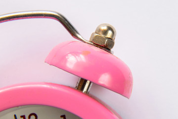 pink alarm clock close-up on an isolated background