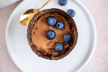 Tiramisu dessert in chocolate cup with berries