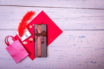 Red envelope or letter, gift, paper card on rustic wooden table for greeting on Mother or Woman Day. Empty copy space for text or greating.