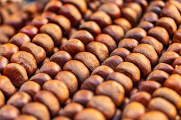 Ripe brown chestnuts closeup, food background, street food market