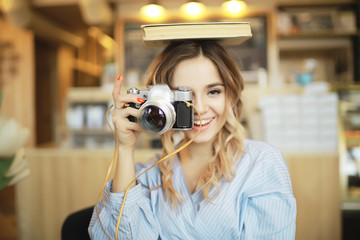 vintage camera girl / beautiful young model holding an old camera in her hands, taking pictures, learning photos