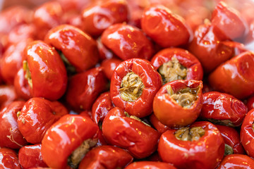 Pickled cherry, Hot cherry peppers stuffed with anchovies and capers, closeup, Italian traditional dish, peppers background, street food market 