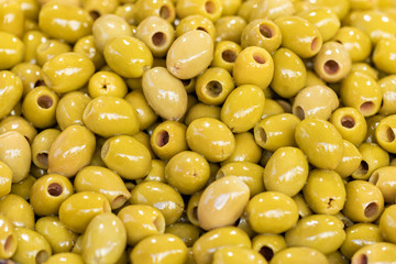 Green pitted olives closeup, background of green olives, food street market 