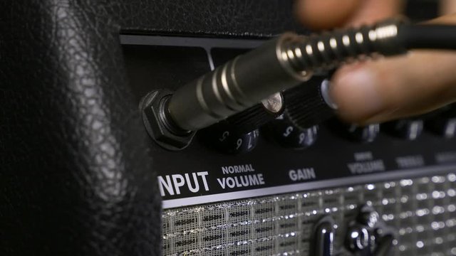 Musician Hand Turns on Power Button on Vintage Speaker Amplifier and Turning Knobs. Rocker Records Music at Home Studio. 4K 10-bit H Hybrid Log Gamma HLG HDR 23.98p