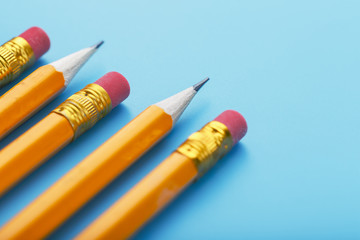 Orange pencils with an eraser on a blue background.