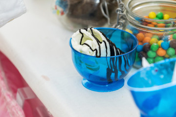 preparation of ice cream with candy drops at a children's party, sprinkled with chocolate