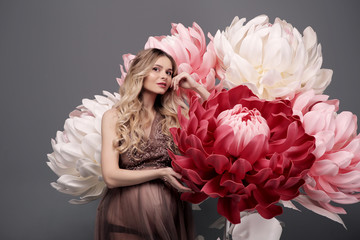 Beautiful pregnant blonde girl portrait with a big bouquet of white flowers.
