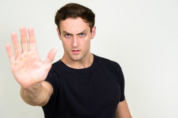 Portrait of stressed young man looking angry with stop gesture