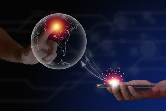 Communication and network concept. Hand touching on transparent erath and hold smartphone with white arrow on blue technology background.