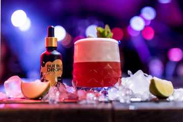 Bright cocktails - shots at the bar. Colorful footage in a nightclub. Alcoholic drink of different colors. Nightlife scene. Shots at the bar table. Several glasses of alcohol 
