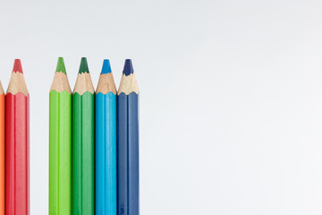 Line of colored pencils isolated on white background