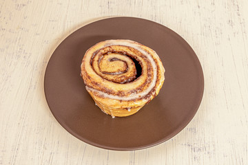 brown plate with cinammon roll