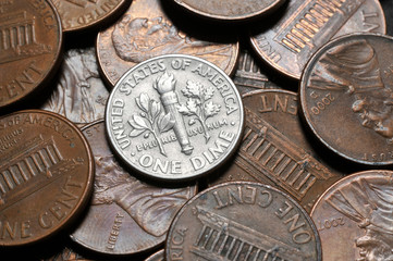 A close up of an United States dime coin (10 cents coin) surrounded by pennies. - obrazy, fototapety, plakaty