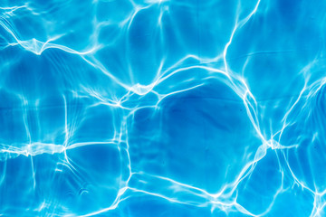 Background of rippled pattern of clean water in a blue swimming pool