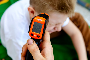 High-temperature quarantine coronavirus in a child. High temperature electronic medical thermometer. To stay at home. Danger Quarantine for the rapid spread of the coronavirus pandemic worldwide.