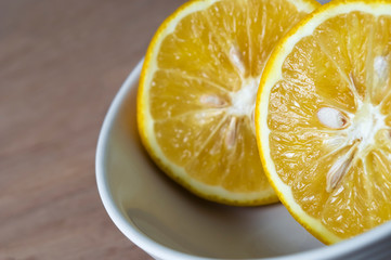 Fototapeta na wymiar A close up of a sliced orange served in a bowl on a tabletop.