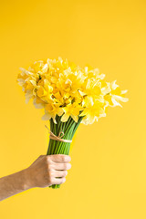 Background male hands with a bouquet of flowers .
