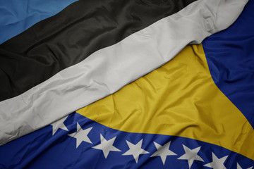 waving colorful flag of bosnia and herzegovina and national flag of estonia.