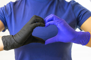 Hands in surgical gloves in the shape of a heart